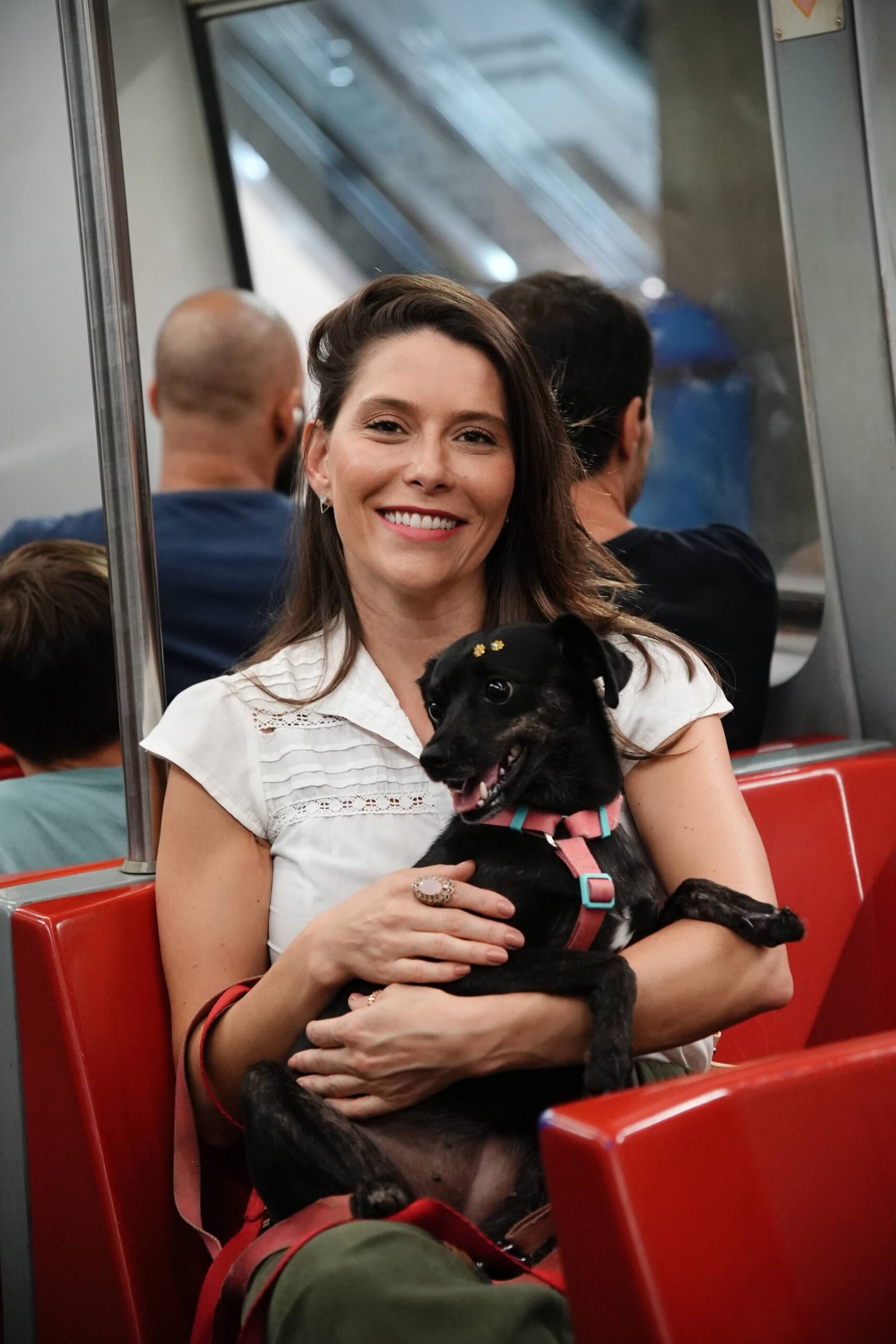 Julia Lucy sentada no metro com cachorro